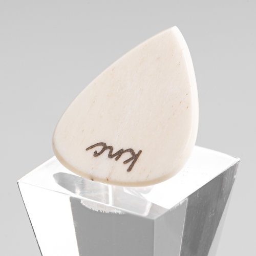 A personalized 'Lil One' bone pick with a custom name laser-engraved on the small surface.