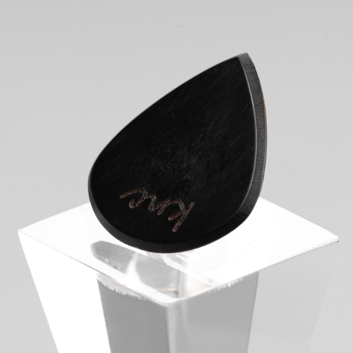 A personalized 'Lil One' horn pick with a custom name laser-engraved on the small, variegated surface.