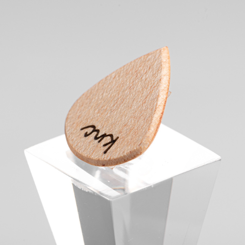 A personalized 'Lil One' Maple pick with a custom name laser-engraved on the small, light wood surface.