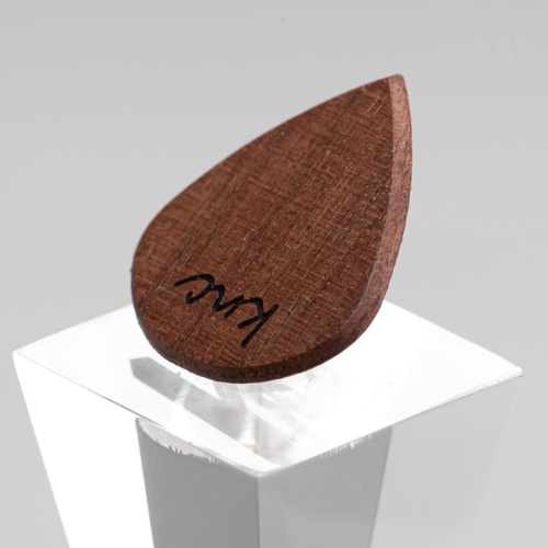 A personalized 'Lil One' Walnut pick with a custom name laser-engraved on the small, dark wood surface.
