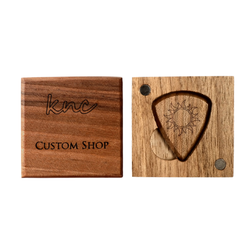A handmade Knc Picks wooden pick, laser-engraved with the 'Burning Sun' design, shown in its premium, wax-sealed wooden gift box.