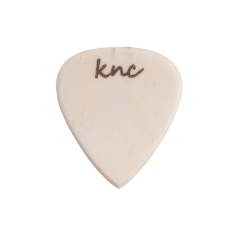 A handmade Knc Picks Custom Bone Pick, showing its natural white/off-white color and polished texture.