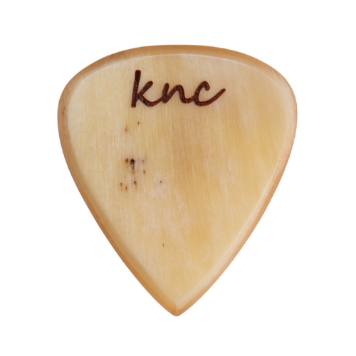 A handmade Knc Picks Custom Horn Pick, showing its unique natural variegated color pattern (yellows, browns, blacks).