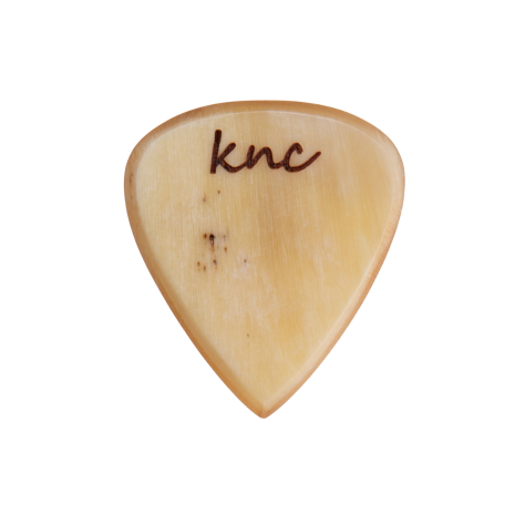 A handmade Knc Picks Custom Horn Pick, showing its unique natural variegated color pattern (yellows, browns, blacks).