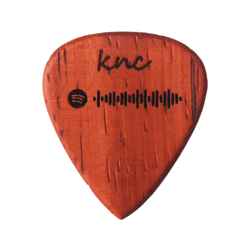 A handmade Knc Picks wooden guitar pick featuring a custom, scannable Spotify code laser-engraved on the surface.