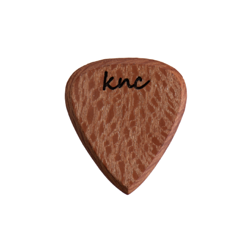 A handmade Knc Picks guitar pick crafted from natural Sycamore (Lacewood), showing its unique, speckled 'lacy' grain pattern.