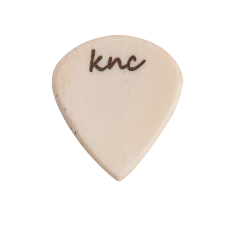 A Knc Picks handmade 'Lil One' (Jazz-style) guitar pick, crafted from natural bone, highlighting its small, sharp shape.