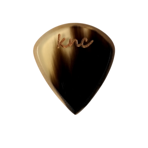 A Knc Picks handmade 'Lil One' (Jazz-style) guitar pick, crafted from natural variegated horn, highlighting its small, sharp shape.