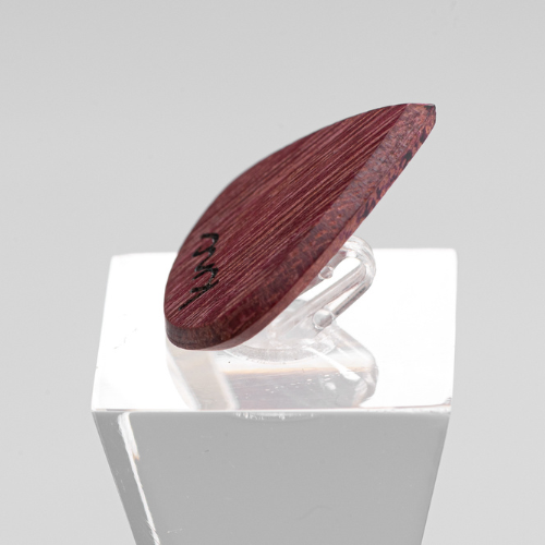 A Knc Picks handmade 'Lil One' (Jazz-style) guitar pick, crafted from vibrant natural Purpleheart wood, highlighting its small, sharp shape.