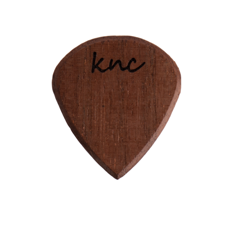 A Knc Picks handmade 'Lil One' (Jazz-style) guitar pick, crafted from natural Walnut wood, highlighting its small, sharp shape and dark grain.