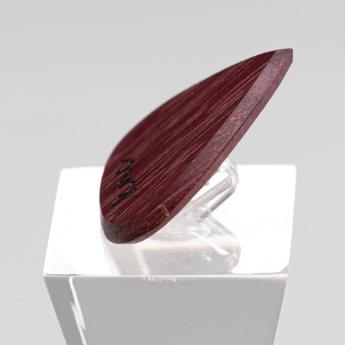 A handmade Knc Picks guitar pick crafted from natural Purpleheart (Morkalp) wood, showing its deep, vibrant purple color.