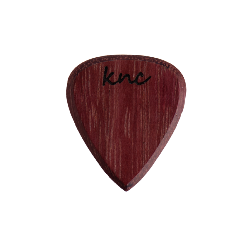 A handmade Knc Picks guitar pick crafted from natural Purpleheart (Morkalp) wood, showing its deep, vibrant purple color.