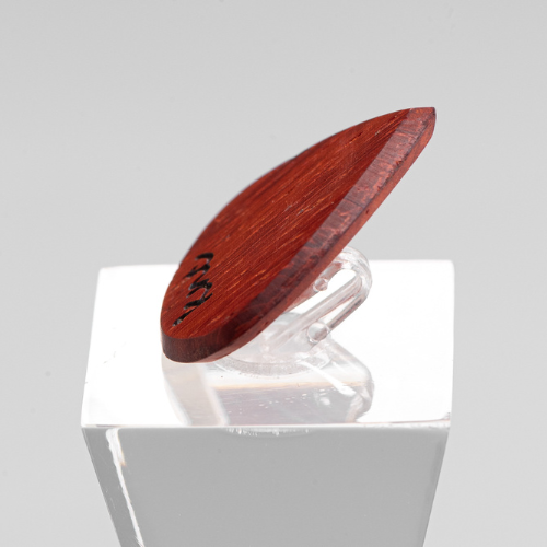 The 'Lil One' Padouk pick shown next to a standard-sized pick to compare its small, Jazz-style shape.