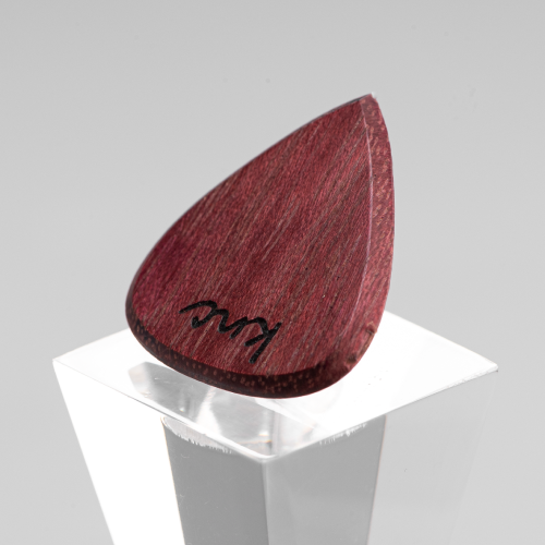 Close-up detail of the natural purple color and wood grain of the Purpleheart pick used for the necklace.
