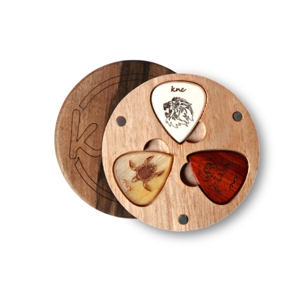 Three custom guitar picks from the Wildlife Series (e.g., Lion, Turtle, Bull) arranged on a dark surface.
